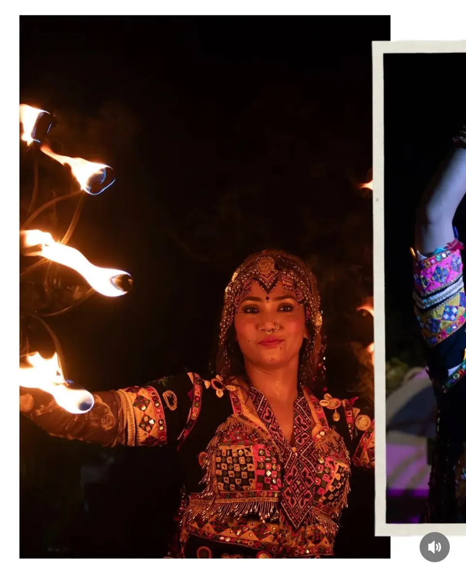 Cultural performer holding fire torches during an evening performance